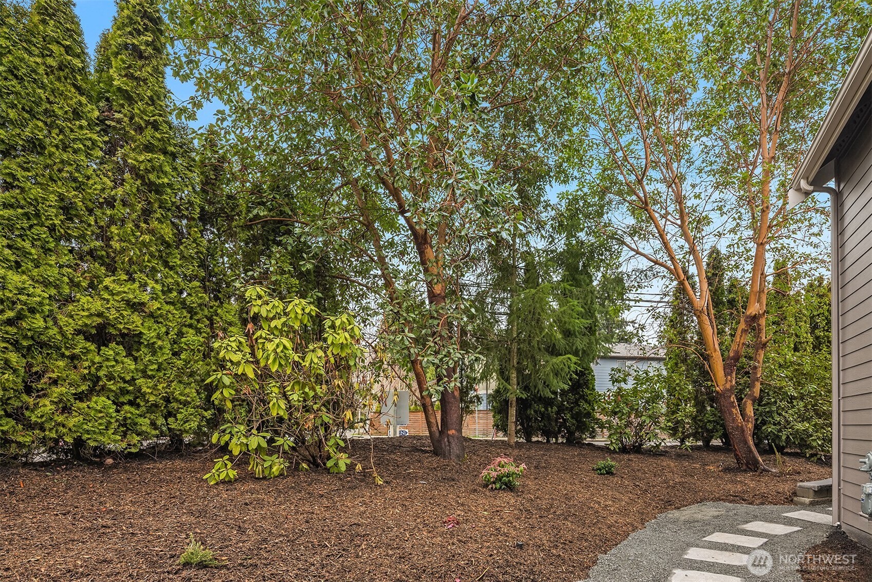 9207 Northeast 175th Street, Unit A Bothell, WA 98011 - Photo 32 of 38 a backyard of a house with lots of trees