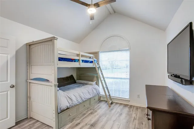 a bedroom with a bed and a flat tv screen on the dresser
