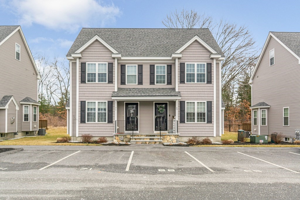 69 Riley Road, Unit 69 Tyngsboro, MA 01879 - Photo 1 of 42 a front view of a house with a garden