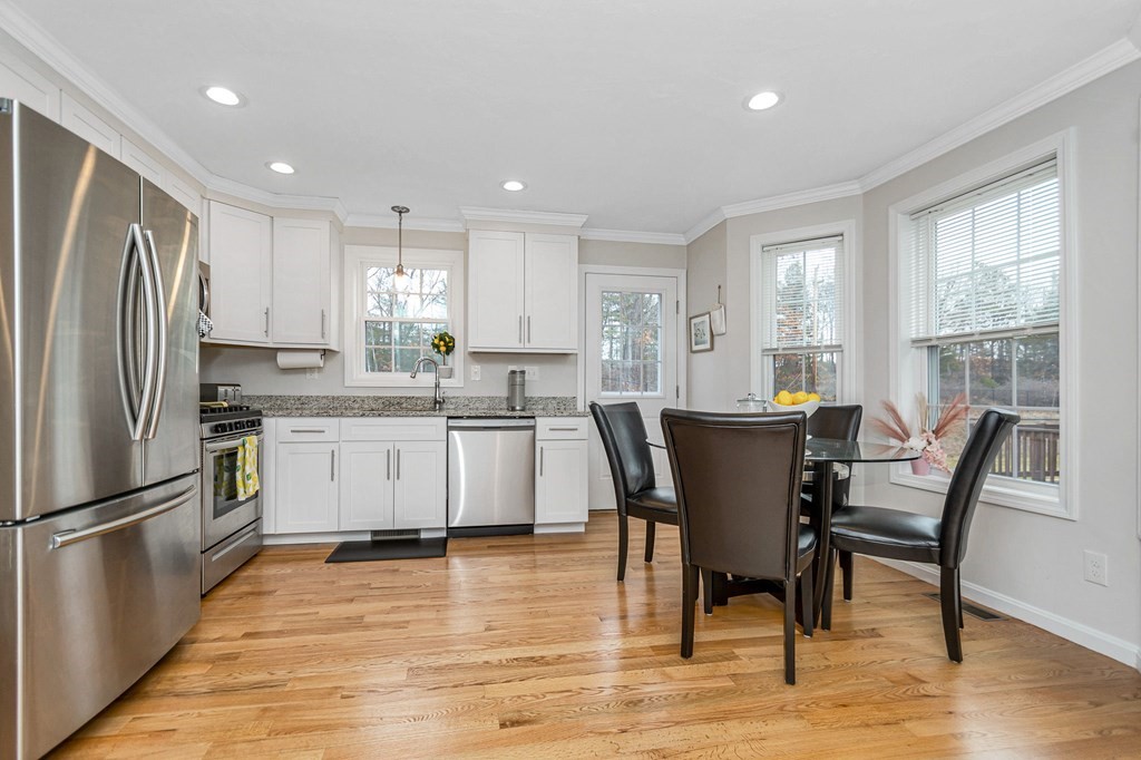 69 Riley Road, Unit 69 Tyngsboro, MA 01879 - Photo 7 of 42 a kitchen with stainless steel appliances granite countertop a dining table chairs refrigerator and sink