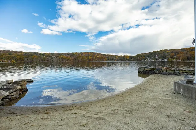 a kitchen with stainless steel appliances granite countertop a stove a refrigerator a sink a dining table and chairs