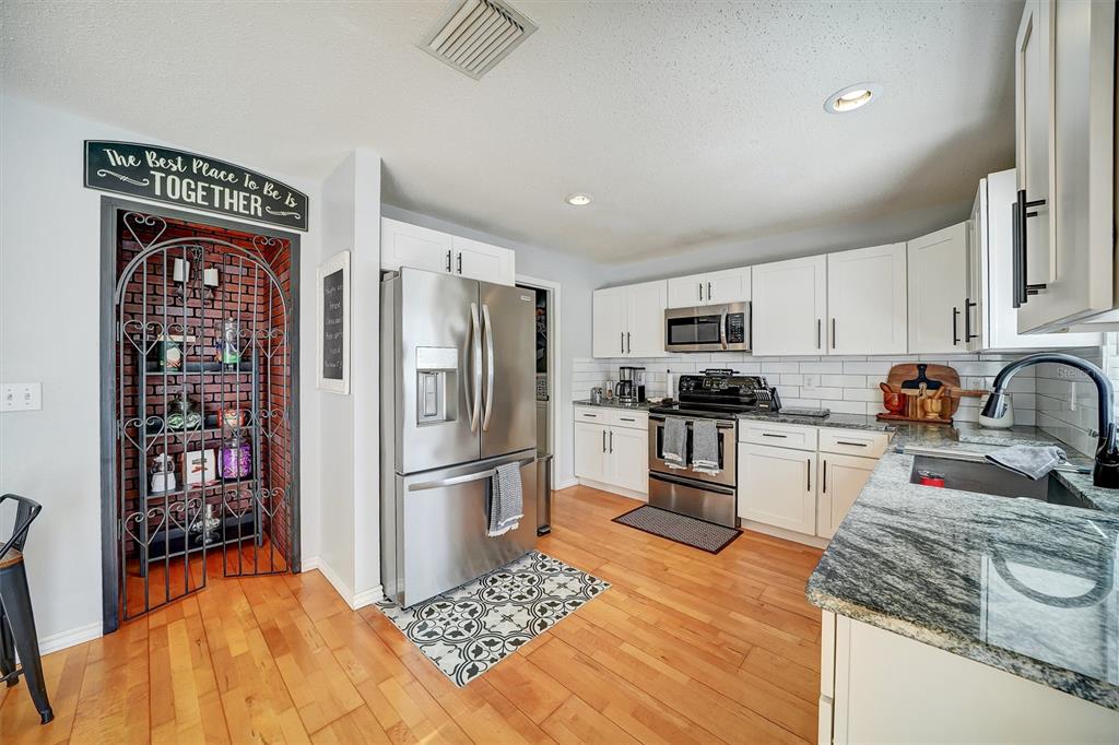 13706 Fareham Road Odessa, FL 33556 - Photo 7 of 21 a kitchen with stainless steel appliances granite countertop a refrigerator sink and stove