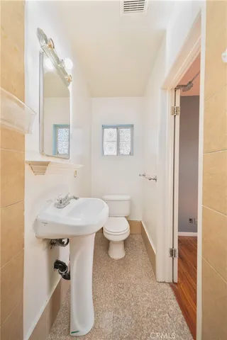 a bathroom with a sink toilet and a mirror