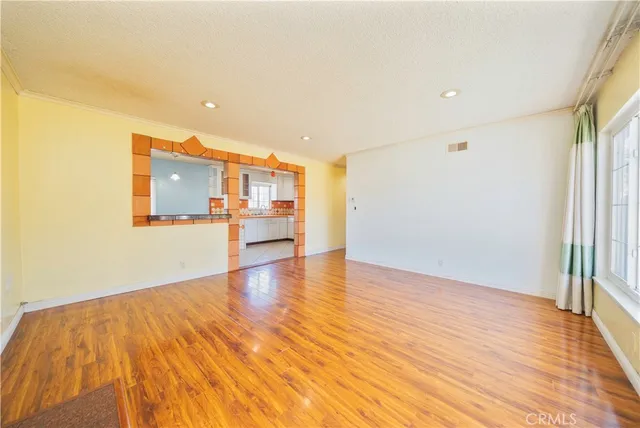 a view of a kitchen with wooden floor and a window
