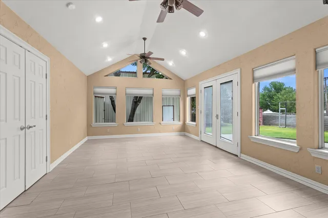a view of an empty room with a window and chandelier