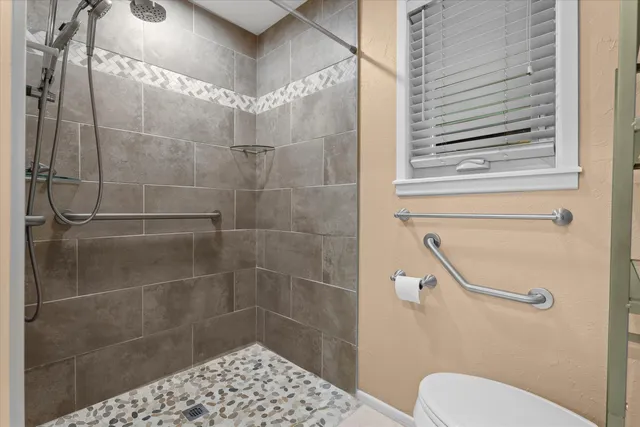 a bathroom with a toilet and a shower