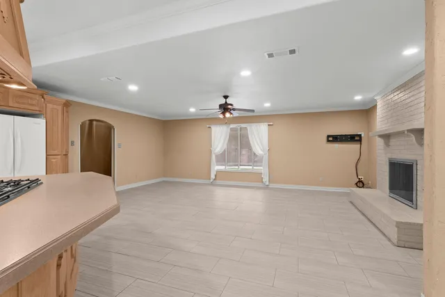 a view of an empty room with a fireplace and a window