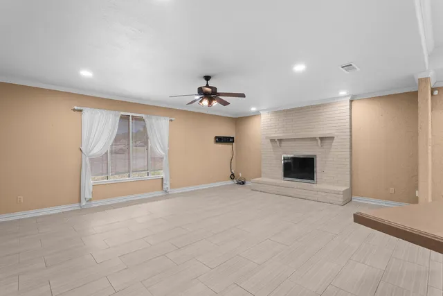a view of an empty room with a fireplace and a window