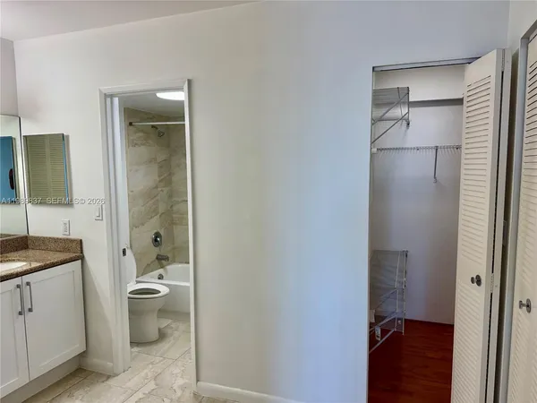 a bathroom with a granite countertop sink toilet and shower