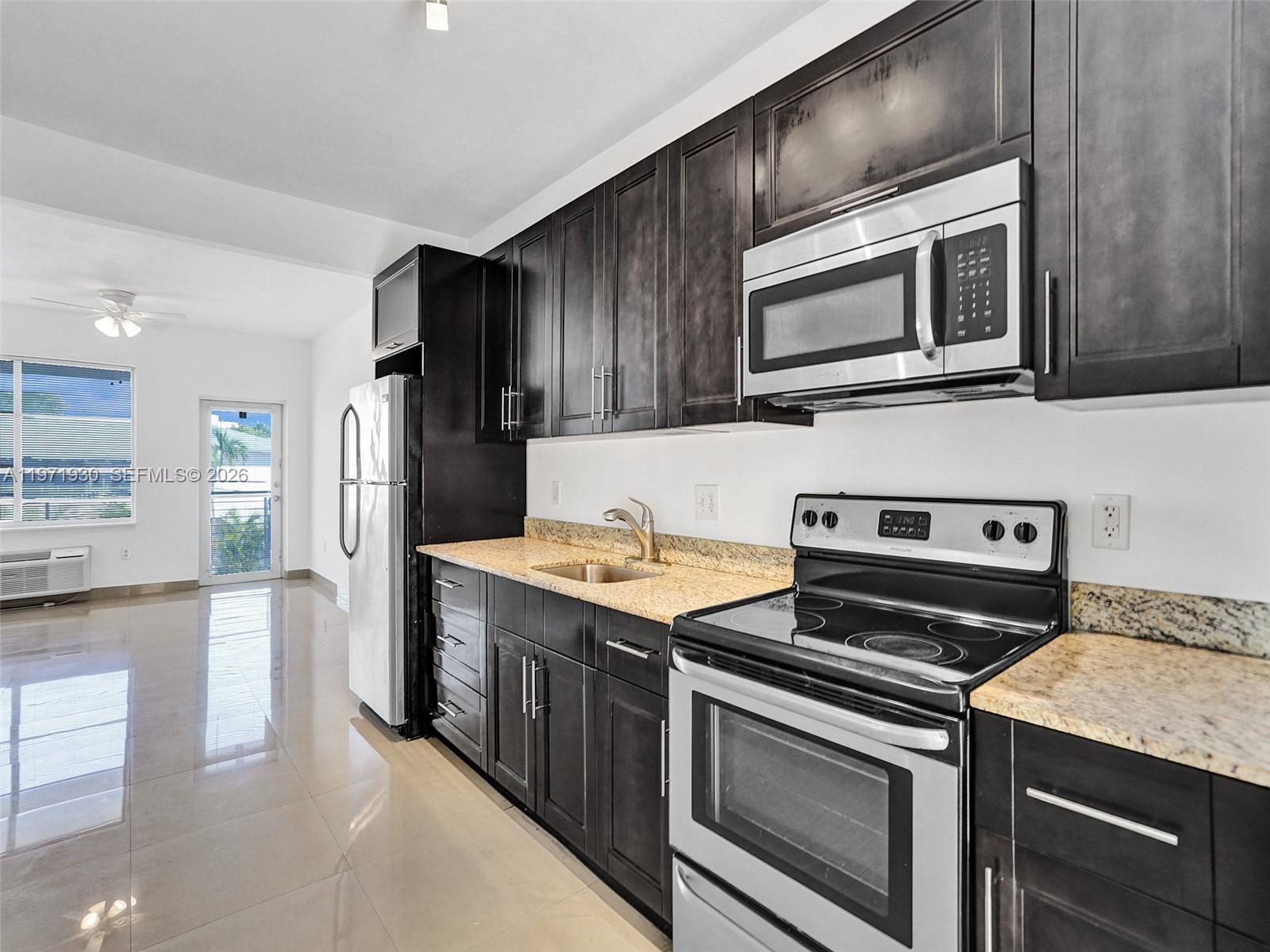 540 74th Street, Unit 10 Miami Beach, FL 33141 - Photo 13 of 27 a kitchen with stainless steel appliances and cabinets
