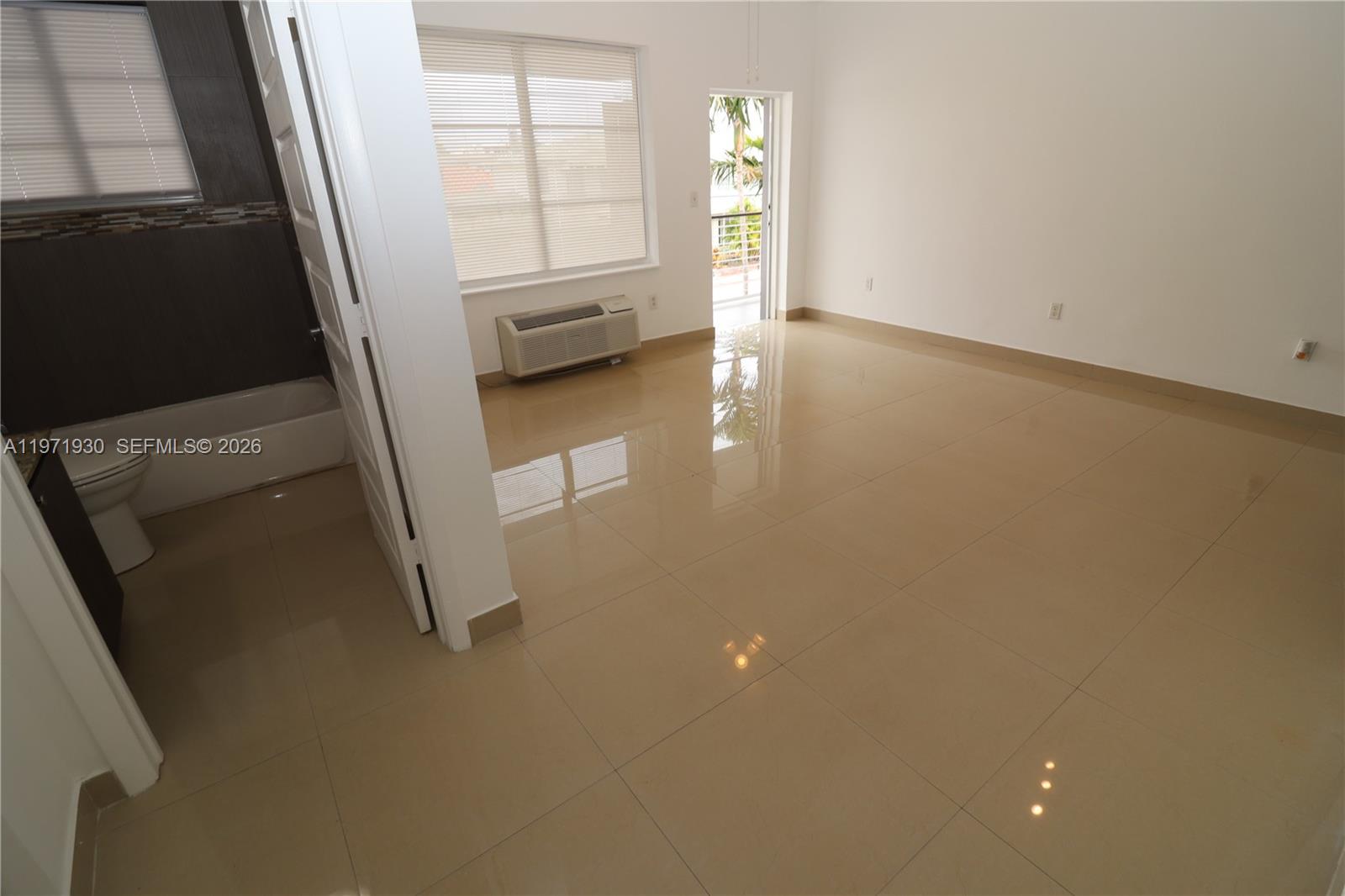 540 74th Street, Unit 10 Miami Beach, FL 33141 - Photo 17 of 27 wooden floor in an empty room with a window