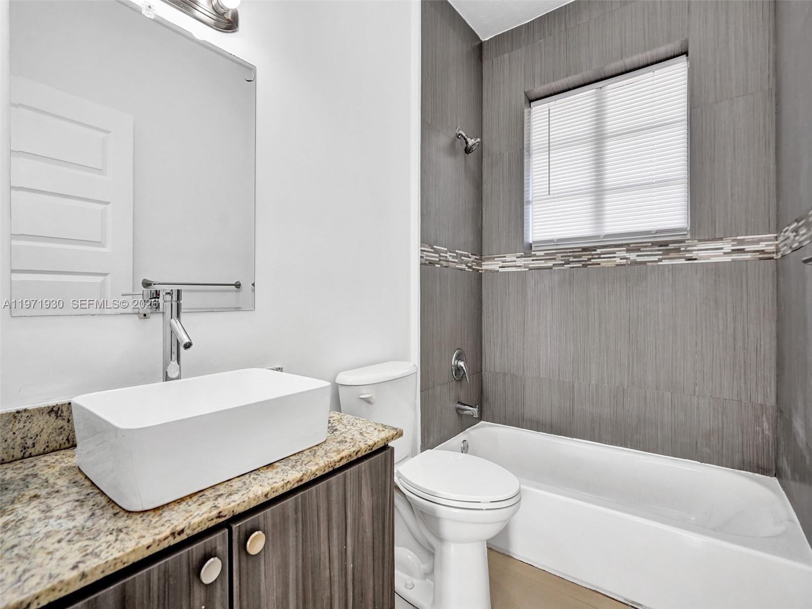 540 74th Street, Unit 10 Miami Beach, FL 33141 - Photo 9 of 27 a bathroom with a sink a toilet and shower