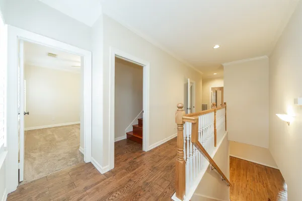 a view of a hallway with wooden floor and entryway
