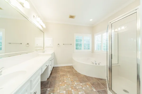 a spacious bathroom with a tub sink and mirror