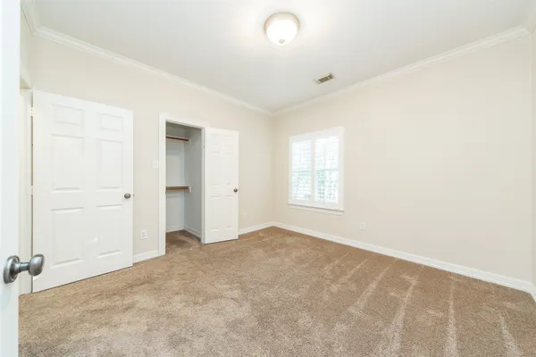 an empty room with windows and closet