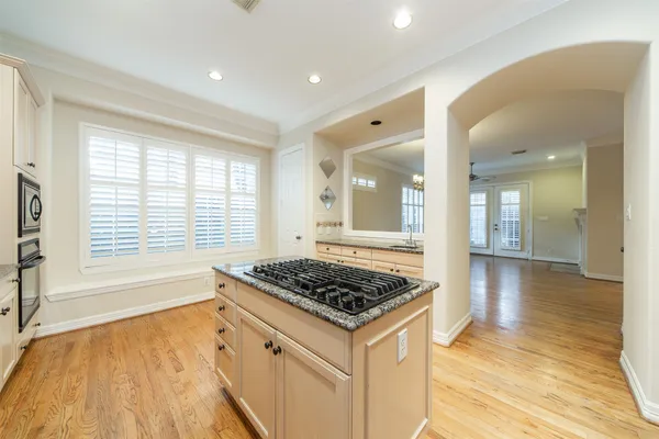 a kitchen with stainless steel appliances granite countertop a stove and a wooden floors