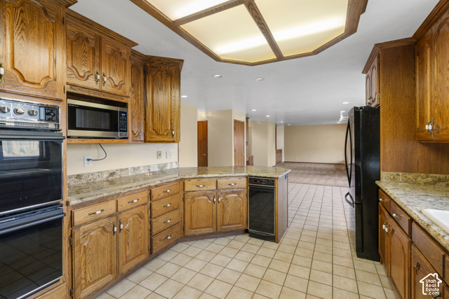 1373 Pheasant Ridge Circle Bountiful, UT 84010 - Photo 8 of 50 Kitchen featuring wood cabinetry, light-toned countertops, tile flooring, and integrated black appliances