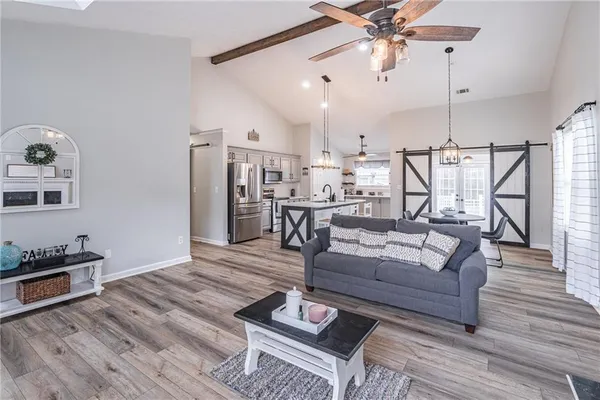 a living room with furniture and kitchen view