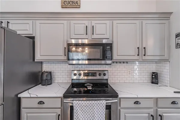 a kitchen with white cabinets and appliances