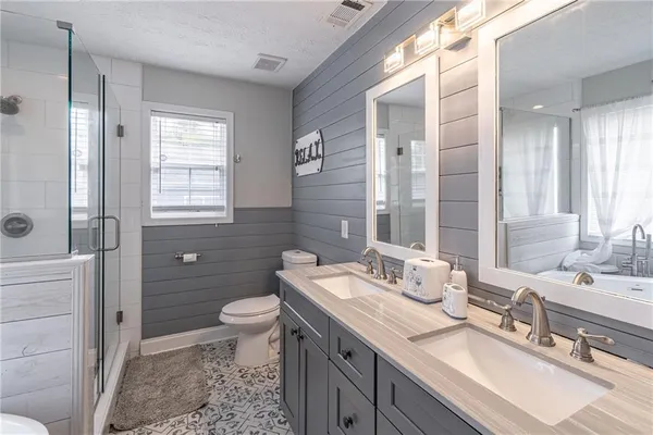 a bathroom with a double vanity sink toilet and shower