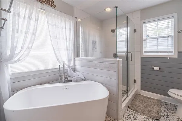 a white bath tub sitting in a bathroom next to a window