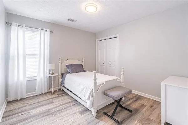 a bedroom with a bed and wooden floor
