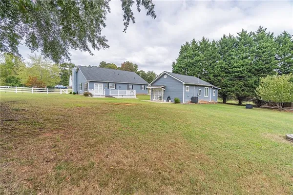 a view of backyard with wooden floor and fence