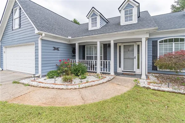 a front view of a house with a garden and plants