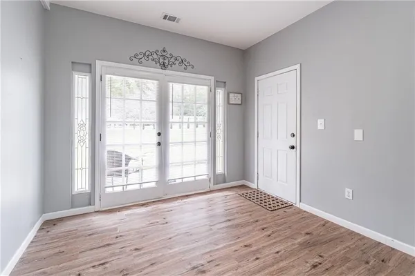 an empty room with wooden floor and windows