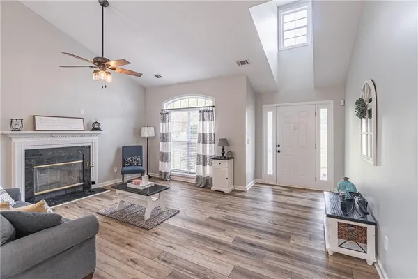 a living room with furniture a fireplace and wooden floor