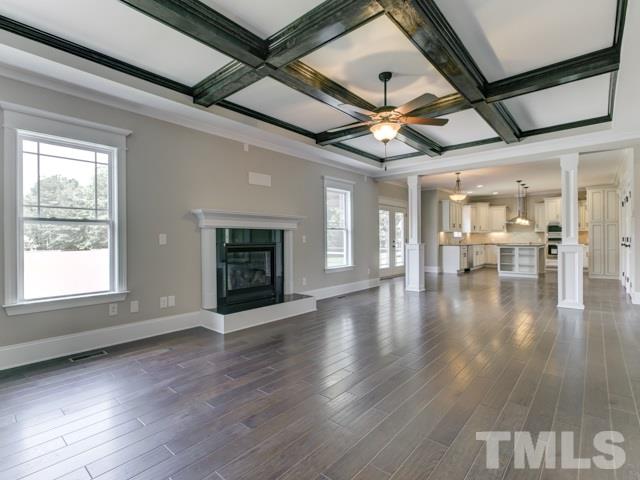 9814 Chris Drive Raleigh, NC 27603 - Photo 11 of 25 a view of an empty room with wooden floor a ceiling fan and windows