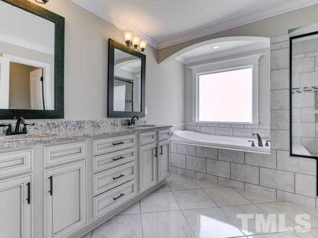 9814 Chris Drive Raleigh, NC 27603 - Photo 13 of 25 a bathroom with a double vanity sink mirror and bathtub
