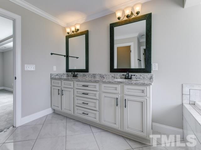 9814 Chris Drive Raleigh, NC 27603 - Photo 15 of 25 a bathroom with a sink vanity and mirror