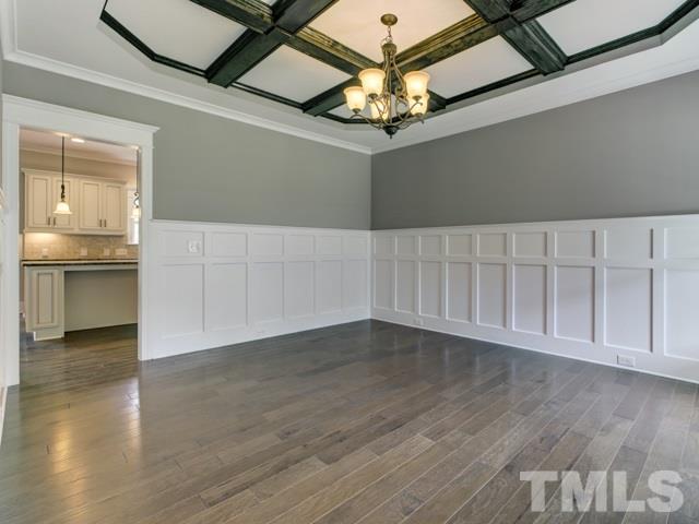9814 Chris Drive Raleigh, NC 27603 - Photo 4 of 25 an empty room with wooden floor chandelier and glass door