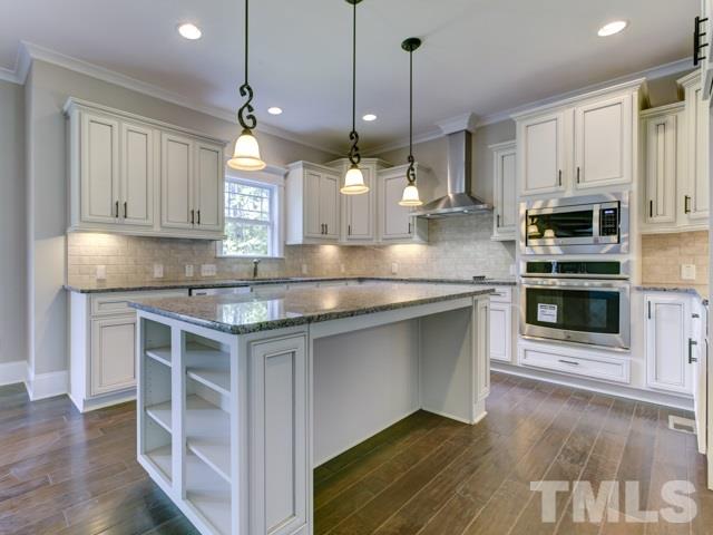 9814 Chris Drive Raleigh, NC 27603 - Photo 5 of 25 a kitchen with stainless steel appliances granite countertop a stove a sink and a wooden floor