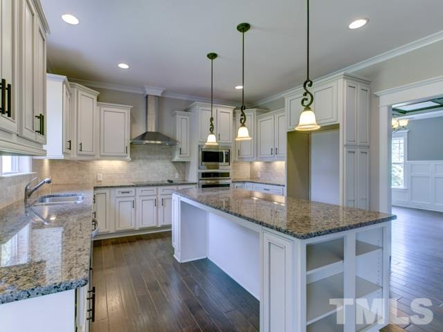 9814 Chris Drive Raleigh, NC 27603 - Photo 7 of 25 a kitchen with granite countertop a sink a counter space appliances and cabinets