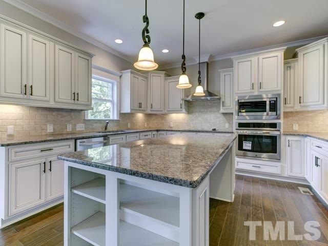 9814 Chris Drive Raleigh, NC 27603 - Photo 8 of 25 a kitchen with kitchen island granite countertop a sink a counter space appliances and cabinets