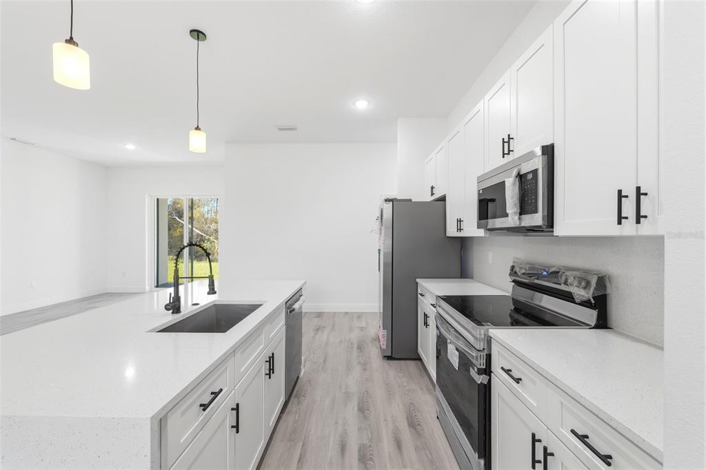 4510 Southwest 155th Street Ocala, FL 34473 - Photo 16 of 40 a kitchen with stainless steel appliances a sink stove and refrigerator
