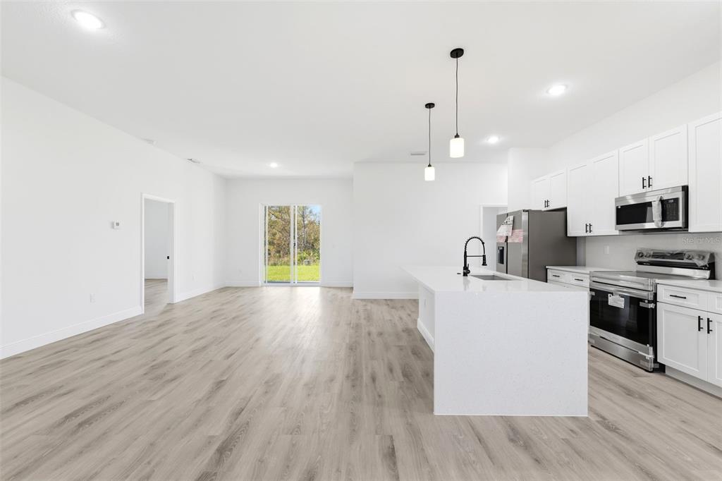 4510 Southwest 155th Street Ocala, FL 34473 - Photo 17 of 40 a view of kitchen with microwave a refrigerator and a stove top oven