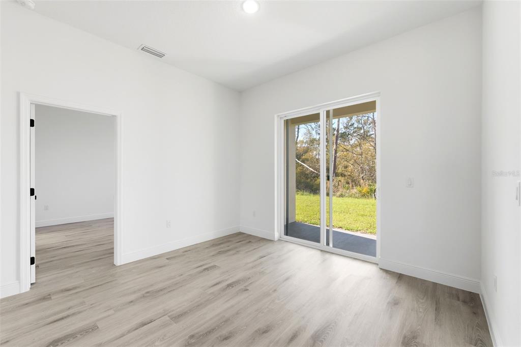 4510 Southwest 155th Street Ocala, FL 34473 - Photo 19 of 40 a view of an empty room with wooden floor and a window