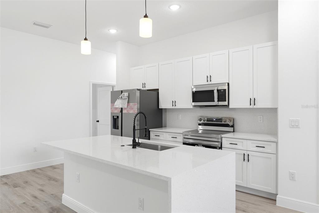 4510 Southwest 155th Street Ocala, FL 34473 - Photo 10 of 40 a kitchen with stainless steel appliances a refrigerator stove microwave and white cabinets