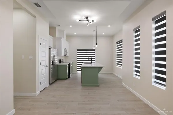 a kitchen with kitchen island a sink and a stove top oven