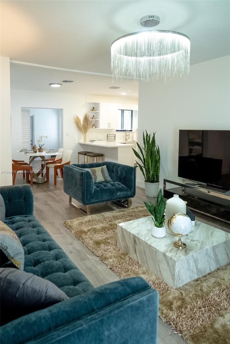 520 Northwest 45th Street, Unit 1 Miami, FL 33127 - Photo 1 of 7 a living room with furniture and a flat screen tv