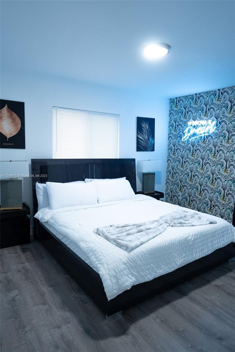 520 Northwest 45th Street, Unit 1 Miami, FL 33127 - Photo 2 of 7 a bedroom with a bed and a night stand