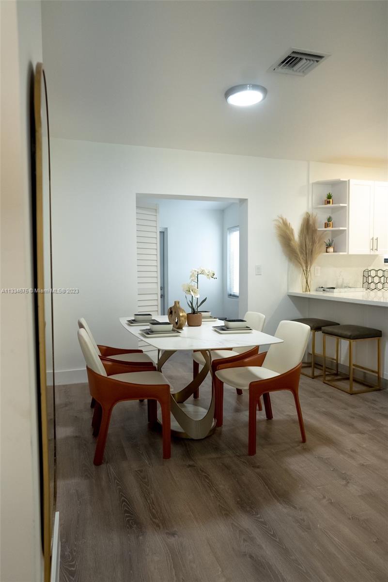 520 Northwest 45th Street, Unit 1 Miami, FL 33127 - Photo 5 of 7 a view of a dining room with furniture and wooden floor