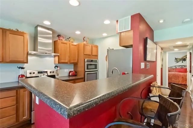 a kitchen with stainless steel appliances granite countertop a sink and a refrigerator