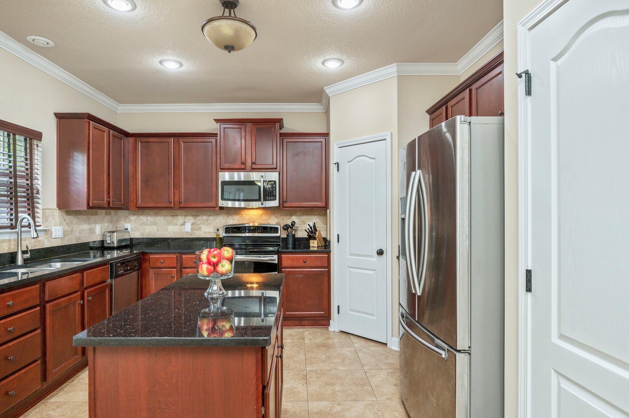 4558 Hermosa Road Crestview, FL 32539 - Photo 16 of 48 a kitchen with stainless steel appliances granite countertop a refrigerator a sink a stove a microwave and island