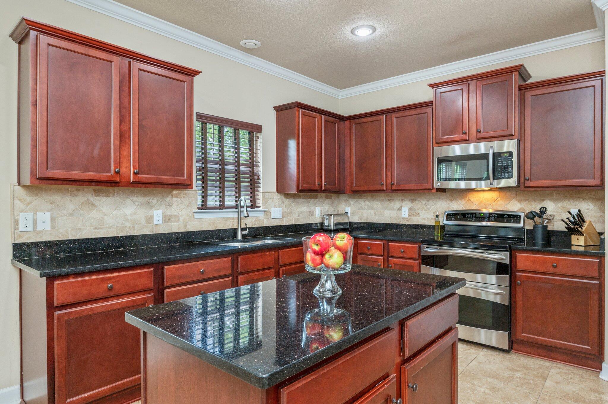 4558 Hermosa Road Crestview, FL 32539 - Photo 17 of 48 a kitchen with stainless steel appliances granite countertop a stove sink and cabinets