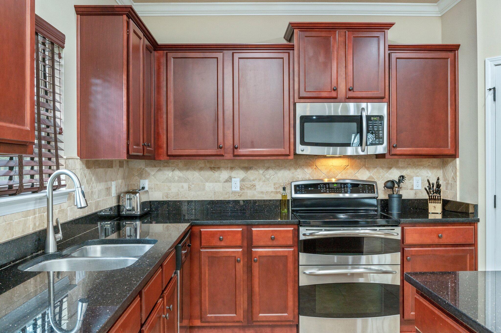 4558 Hermosa Road Crestview, FL 32539 - Photo 18 of 48 a kitchen with granite countertop a stove and cabinets