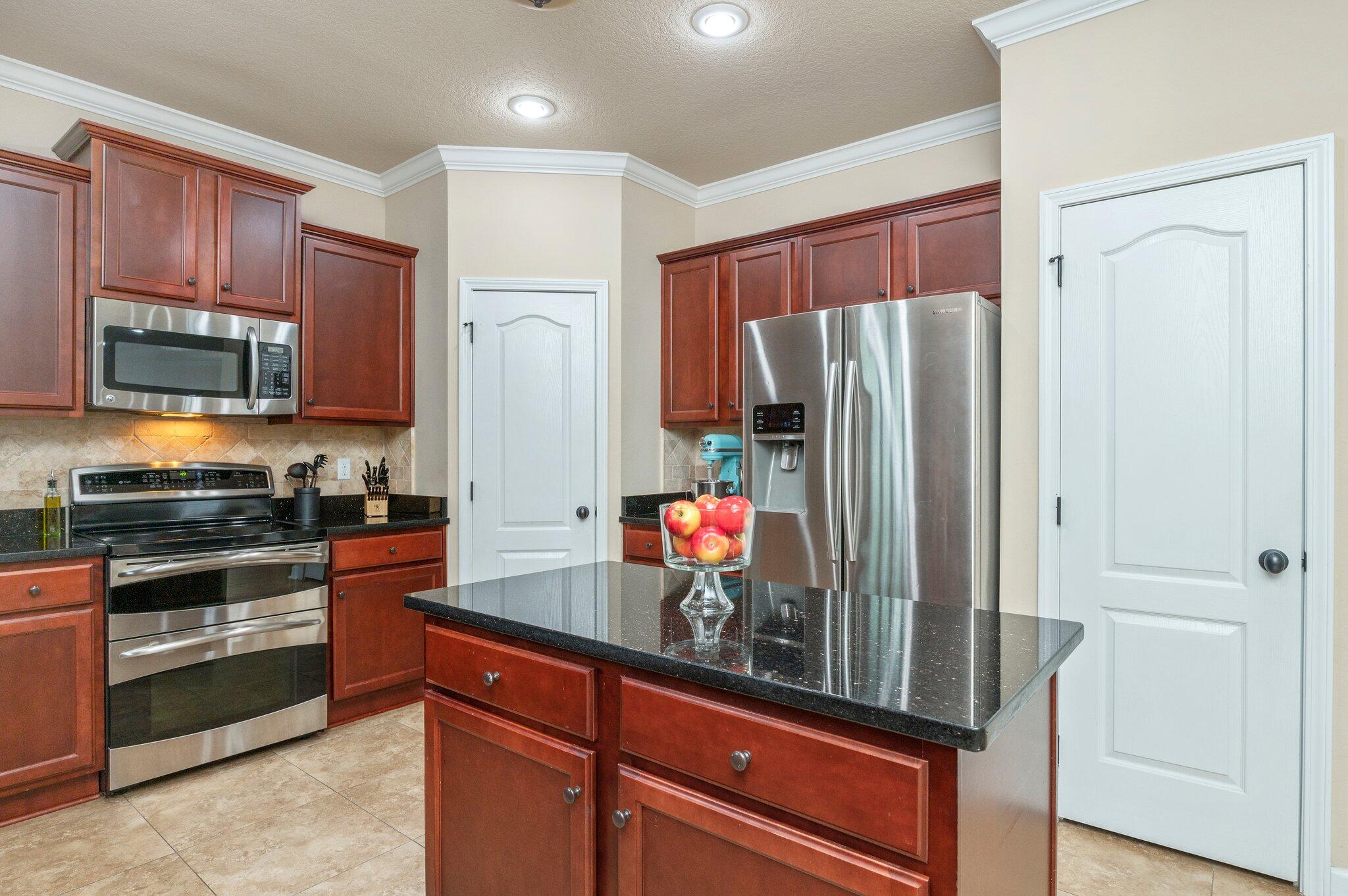 4558 Hermosa Road Crestview, FL 32539 - Photo 20 of 48 a kitchen with stainless steel appliances granite countertop a refrigerator and a stove top oven
